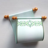 green and gold paper scroll with decorative design