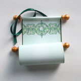 green and gold paper scroll with decorative design 
