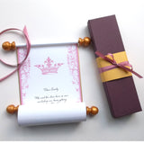 Custom printed white paper scroll with pink crown and design, and a burgundy gift box