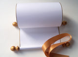 Blank white paper scroll for handwritten wedding vows, gold finials and accents, with white presentation box