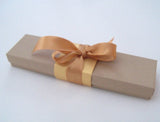 Blank paper scroll on aged parchment, gold finials and kraft box, 5x12" paper