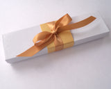 Blank white paper scroll for handwritten wedding vows, gold finials and accents, with white presentation box